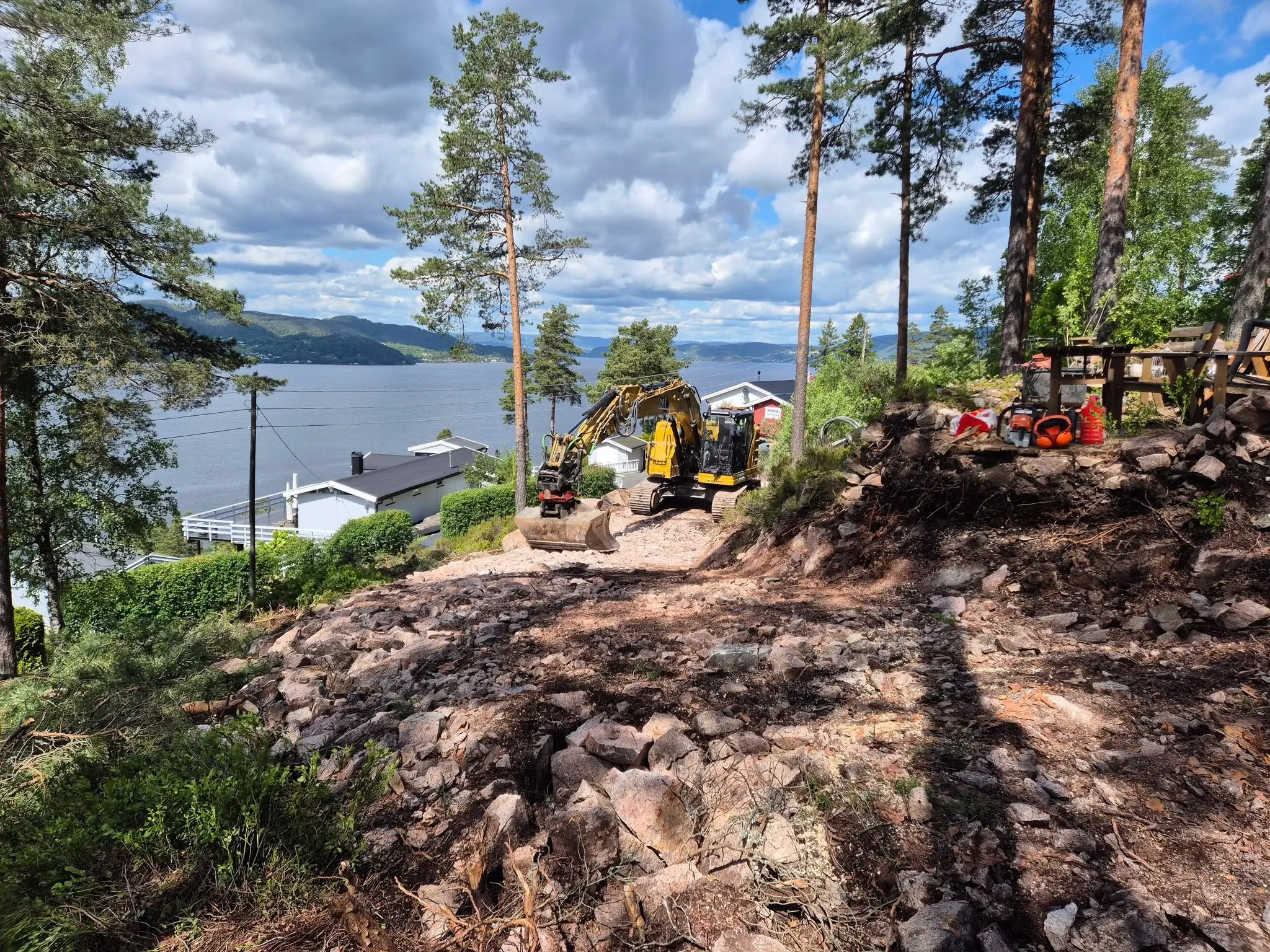 Graving med gravemaskin ved fjorden